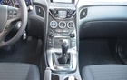 Hyundai Genesis Coup&eacute; 2.0T 2013. La partie centrale verticale s'av&egrave;re tr&egrave;s ergonomique. On retrouve un espace de rangement ferm&eacute; qui contient les entr&eacute;es auxiliaires et iPod (derri&egrave;re le levier de vitesses)