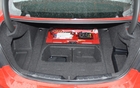 The spare tire has been replaced by a storage compartment. That’s the amp for the audio system and a fuse box at the back.