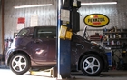 The wee little iQ entering the garage. Note that the open hood is very small and the front overhangs are short. 