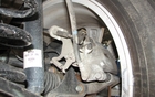 There are standard disc brakes in back. At the top of the photo, you can see that the hand brake cable coming in from the left is mounted directly on the caliper. This design is not the best as it requires frequent maintenance. 